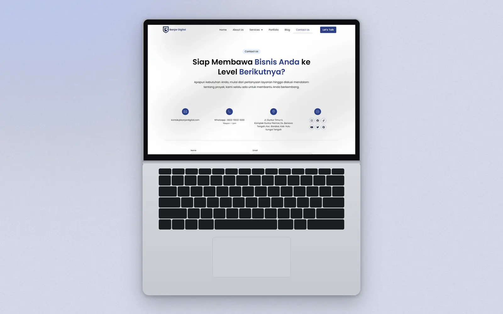 Laptop mockup of the contact page with email, WhatsApp and the office address